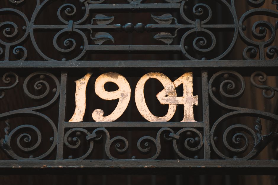 Black metal gate closed across a garden entrance