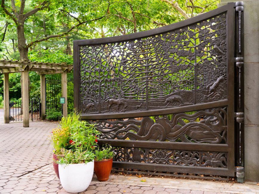 Decorative iron gate with scrollwork set between two posts