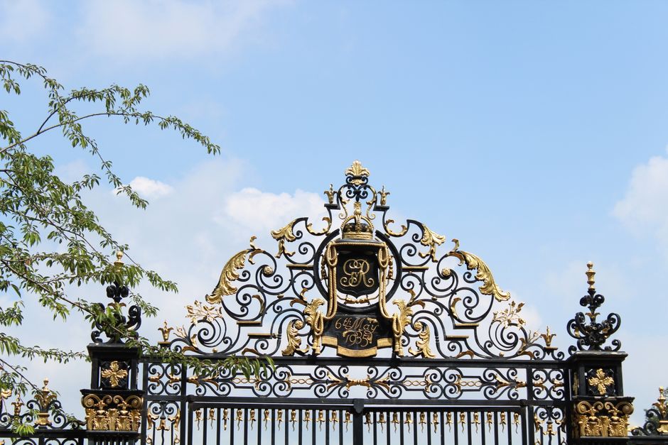 Decorative iron gate with scrollwork set between two posts